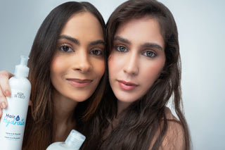 Two women with long hair holding hair care kits by agua de cielo