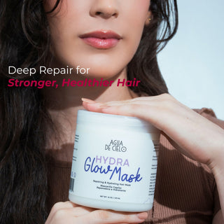 A close-up of a woman holding a white jar of Agua de Cielo Hydra Glow Mask a hair mask for frizzy hair, with text on the left reading 'Deep Repair for Stronger, Healthier Hair'.