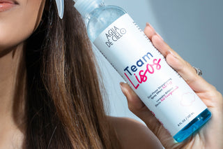 Woman holding 'Team Lisos' , one of the best hair styling products by agua de cielo