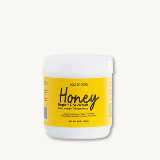 A white plastic jar of Agía de Cielo Honey Repair Pre-Wash, a honey hair mask prepoo, with a bright yellow label, set against a solid off-white background.