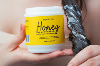 Jar of 'Honey Repair Pre-Shampoo Hair Mask' product held by a person with hair being treated.