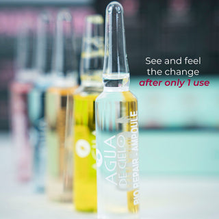 A row of professional style hair ampoules by Agua de Cielo on a light surface, with the front ampoule in sharp focus and the others blurred in the background.
